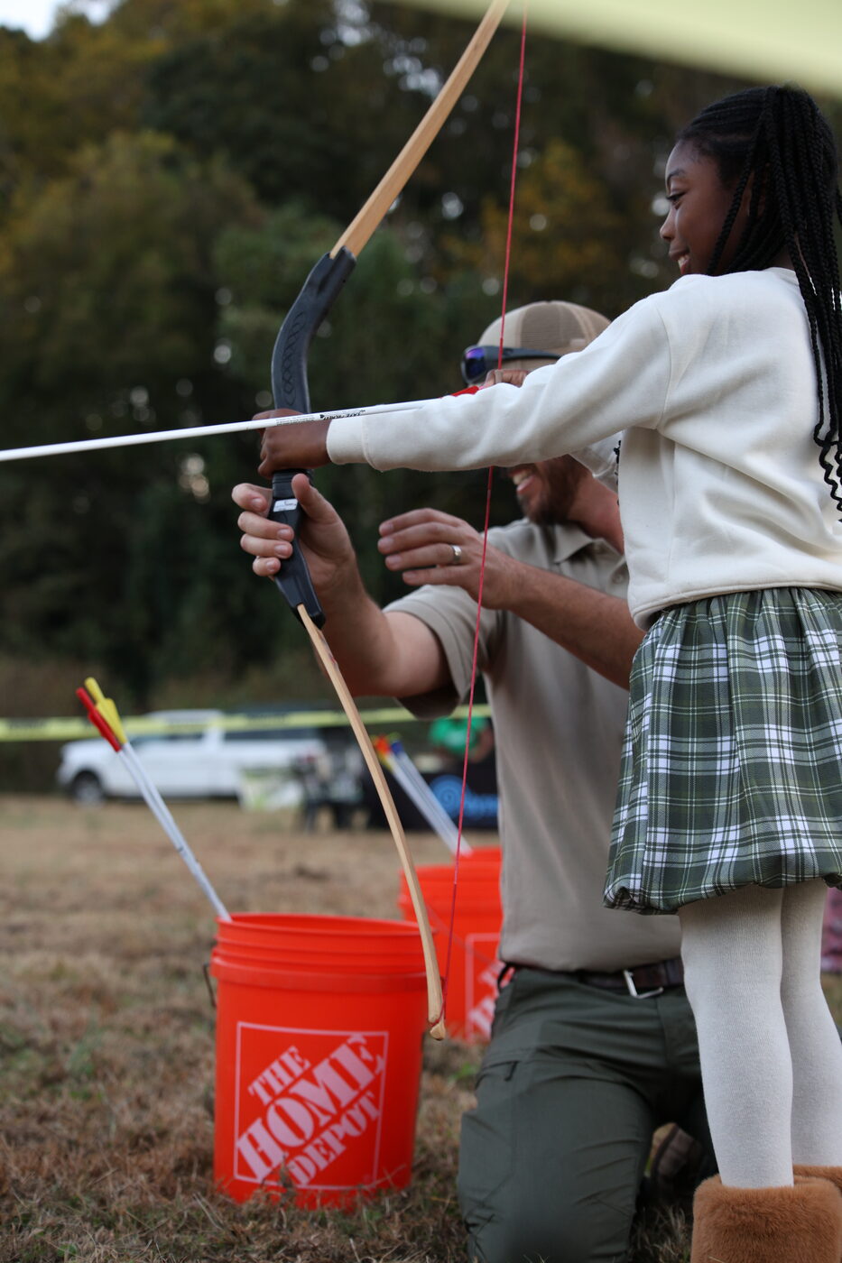 A girl drawing a bow at the archery station at last fall's festival