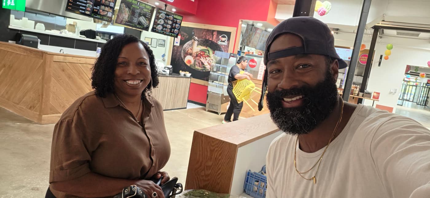 Mark and a customer smiling at the counter on the farm's first sale day at Terminal South