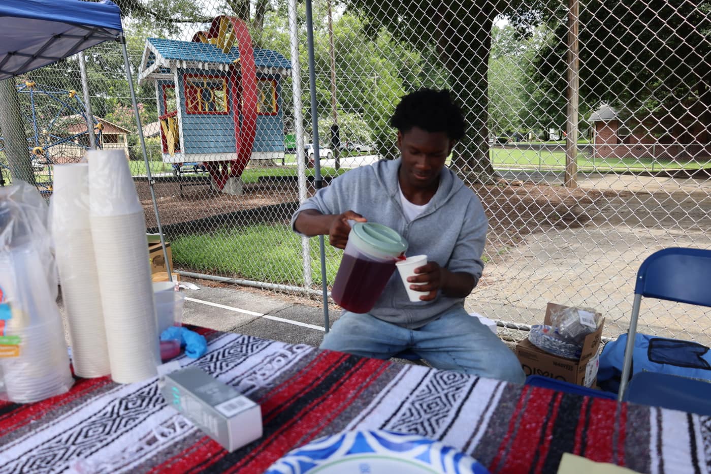 A student pouring a drink at his booth on market day